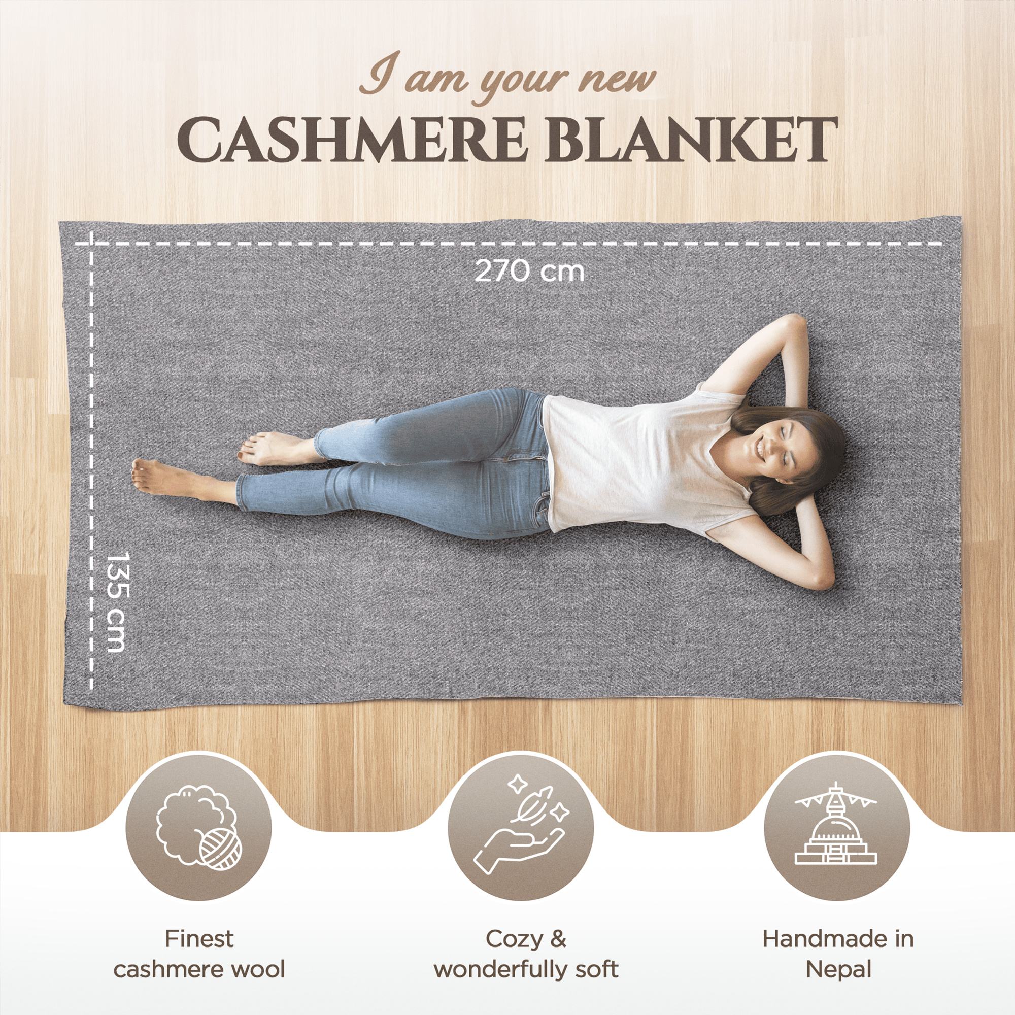 Eine Frau liegt entspannt auf einer großen, dunkelgrauen Kaschmirdecke auf Holzfußboden. Die Decke misst 270 cm x 135 cm. Oben steht der Text „I am your new Cashmere Blanket“. Darunter sind drei Icons: Ein Wollknäuel mit dem Text „Finest cashmere wool“, eine Hand mit dem Text „Cozy & wonderfully soft“ sowie ein stilisiertes Tempelmotiv mit dem Text „Handmade in Nepal“.